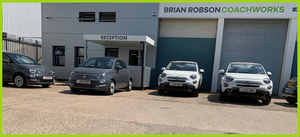 Fleet of Courtesy Cars outside Brian Robson Coachworks bodyworks shop